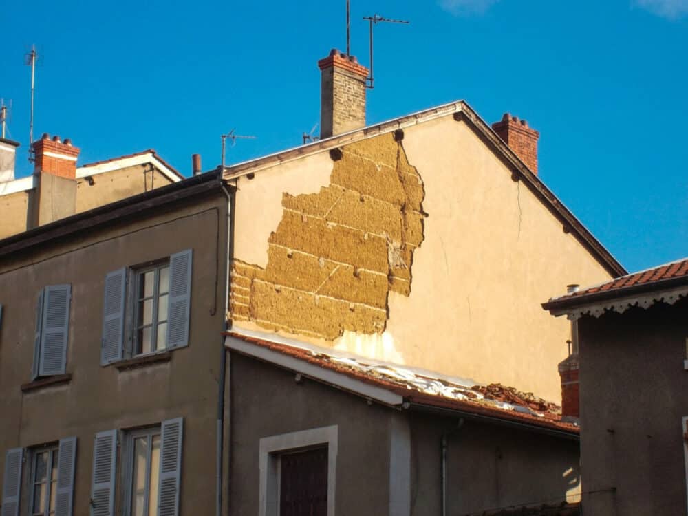 façade extérieure de bâtiment avec mur en terre crue visible